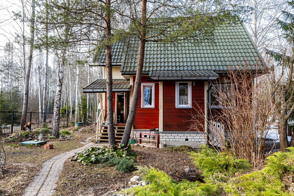 Rött trähus i skogen på landsbygden